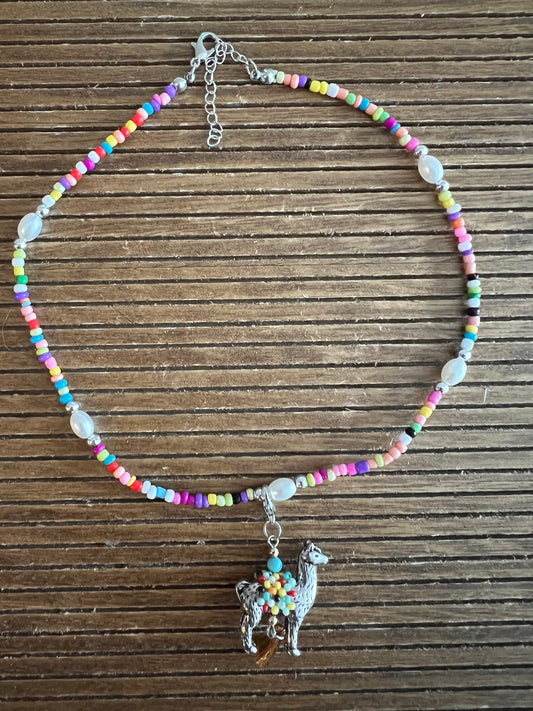 Bead necklace with llama pendant on wooden background