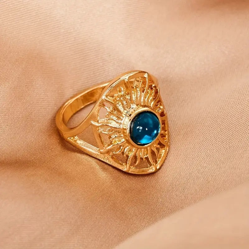 Golden statement ring with sun design and blue round stone