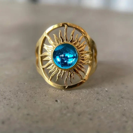 Golden statement ring with sun design and blue round stone